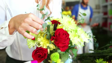 female florist arraigning flower in flower vase