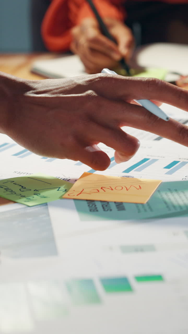 Close-up of Hands Analyzing Business Documents and Charts