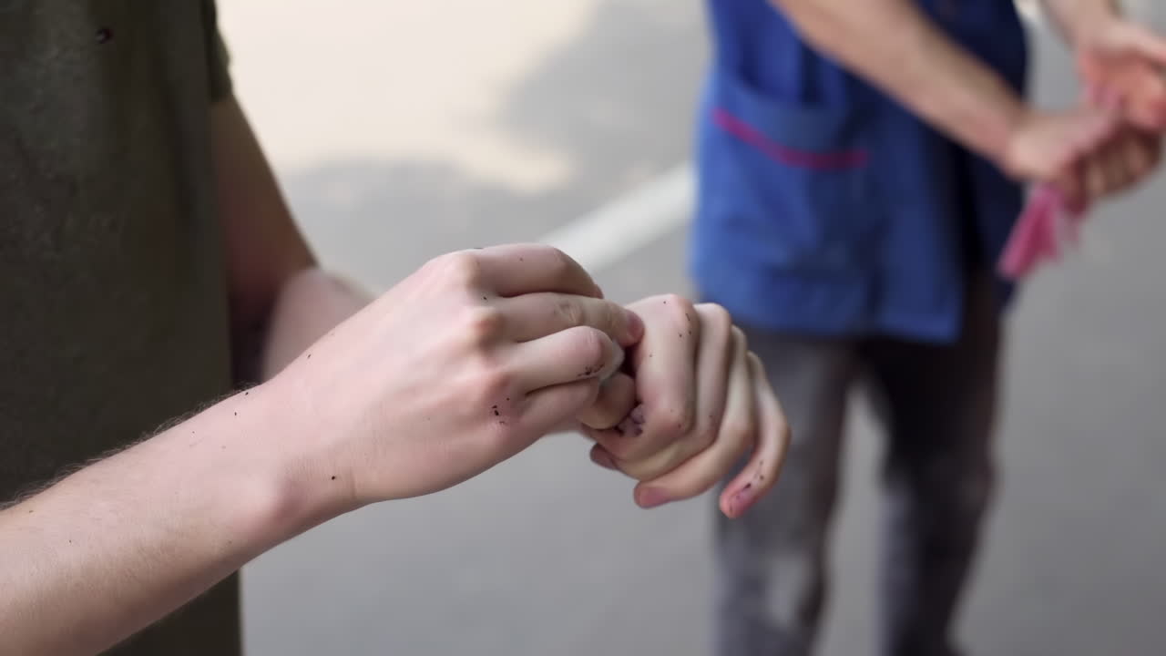 Close up of a man cleaning his hands of black dye with a wet wipe