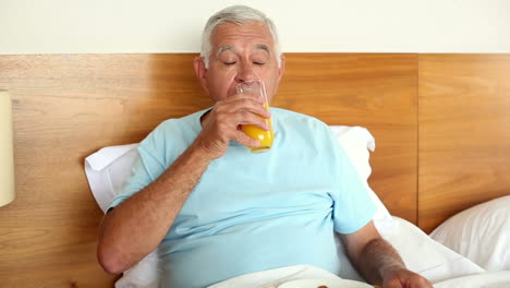 senior man having breakfast in bed