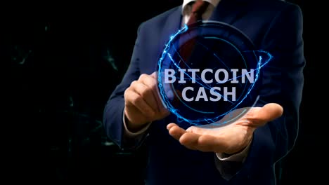 un hombre de negocios muestra un holograma conceptual de bitcoin en efectivo en su mano.