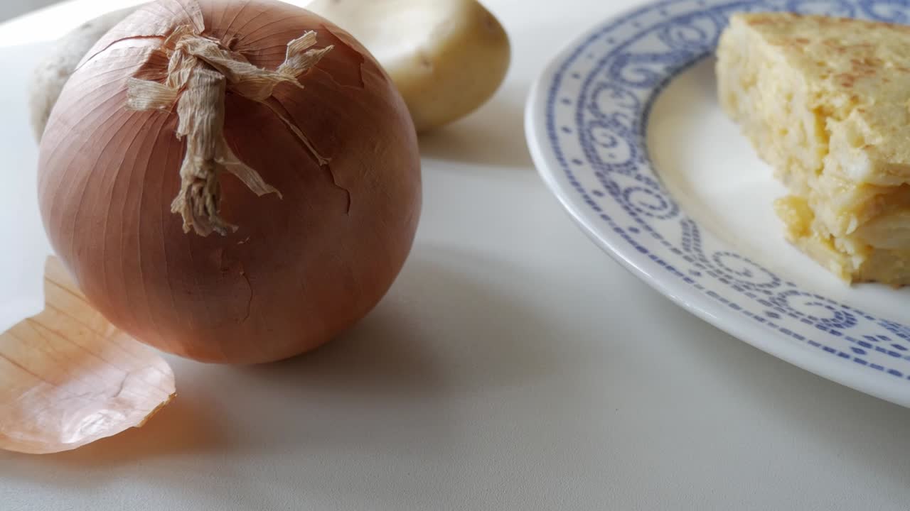 Sliced onion and potato, part of ingredients for preparing a Spanish potato omelette