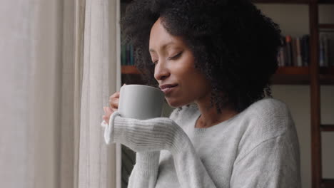 Schöne-Afroamerikanische-Frau-Schaut-Aus-Dem-Fenster,-Trinkt-Kaffee-Und-Genießt-Den-Frischen-Neuen-Tag-Und-Fühlt-Sich-Ausgeruht