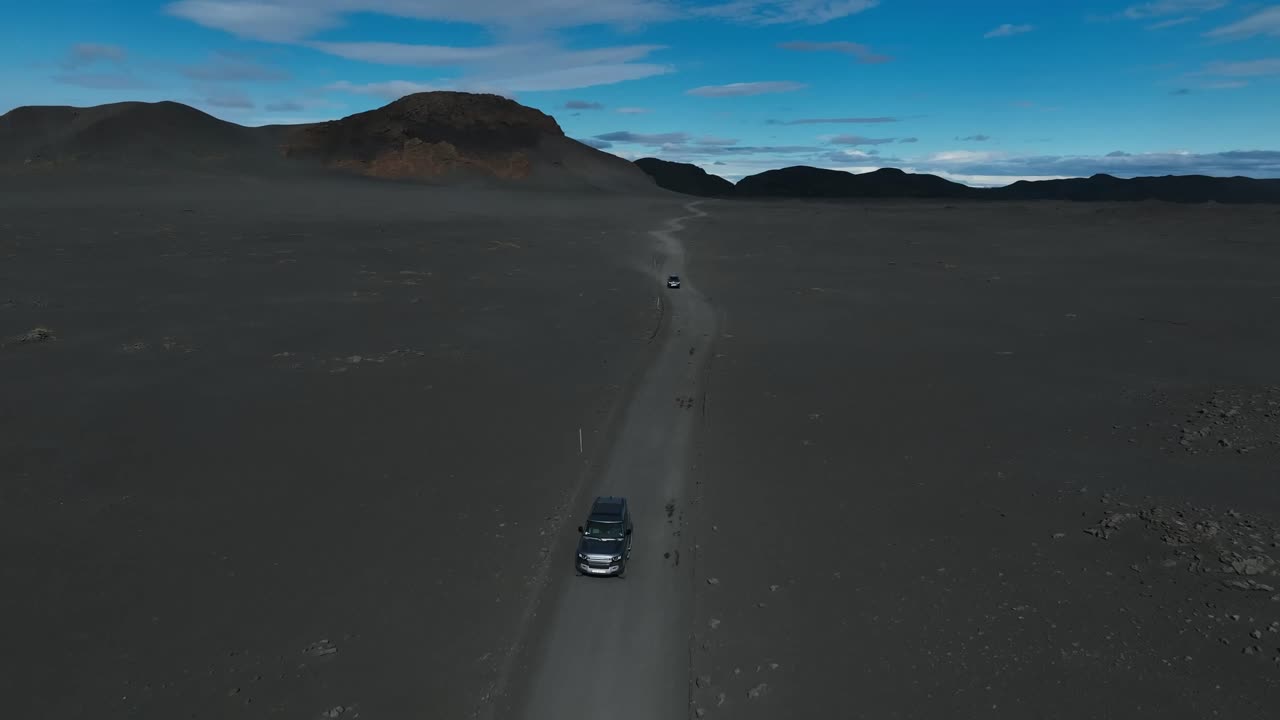 Dronebillede af bil, der kører på turisttur til Island