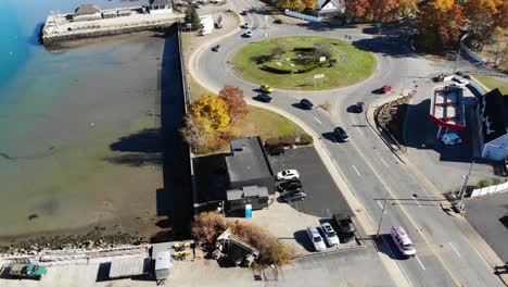 A-drone-view-of-a-busy-rotary-on-the-seacoast-during-a-sunny-summer-day-as-cars-drive-by