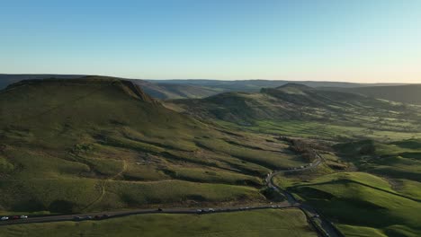 Wide-aerial-establishing-shot-of-Mam-Tor-with-views-across-the-great-ridge-at-Sunrise,-Peak-District,-UK