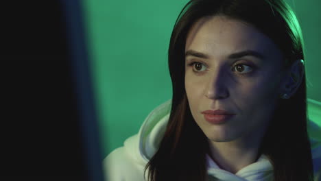 portrait of a modern woman using a computer on a neon light colorful background. close-up.