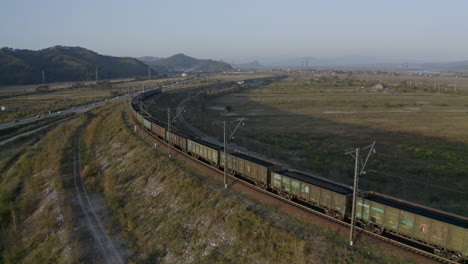 stationary full loaded coal cargo rail carriage locomotive, stopped on the curved turn of the railway, on the sunset