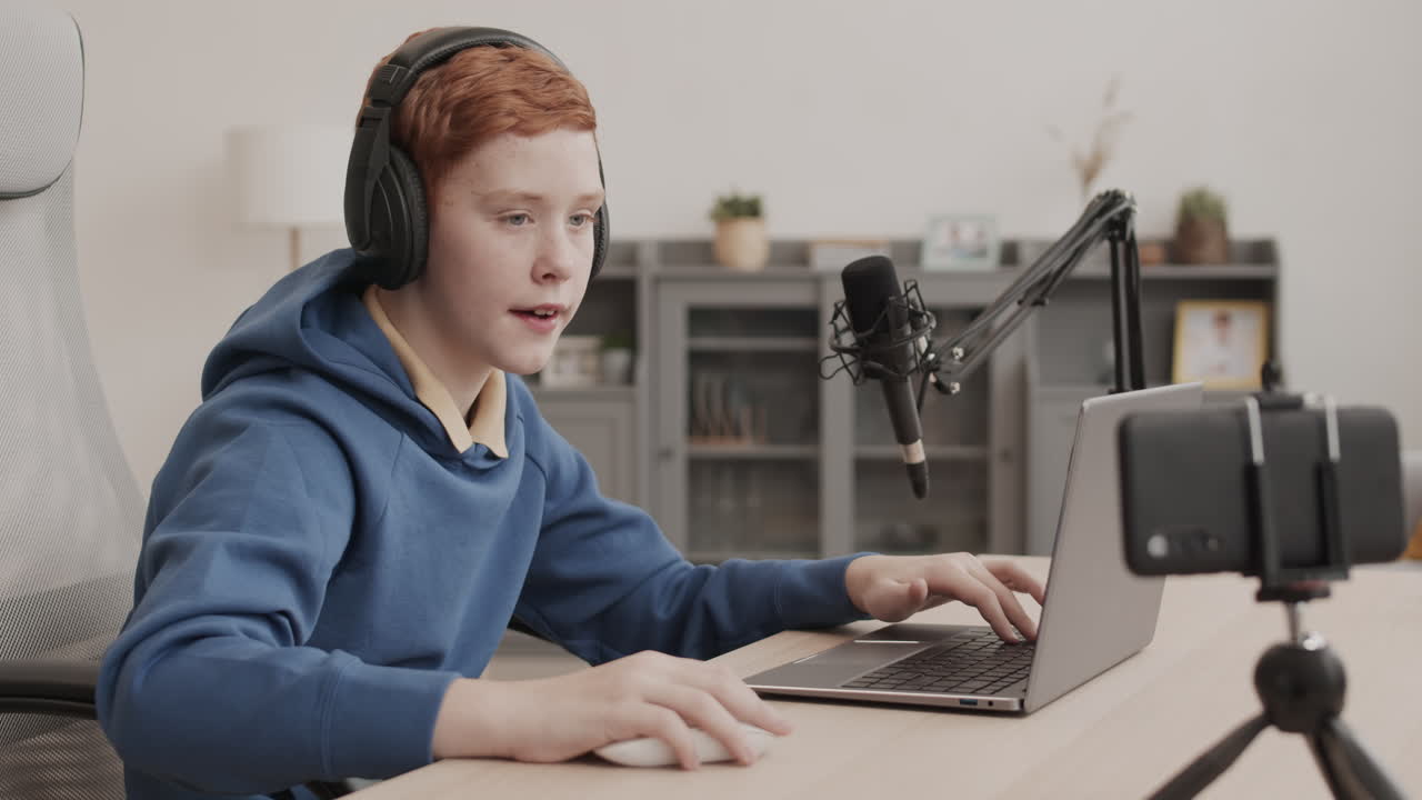 Boy streaming with laptop and microphone