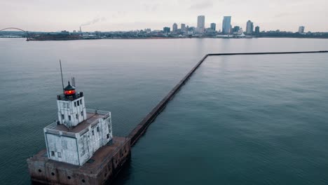 Dramática-Antena-Del-Faro-Del-Rompeolas-De-Milwaukee-Desde-El-Lago-Michigan,-Centro-De-Milwaukee,-Wisconsin,-Estados-Unidos