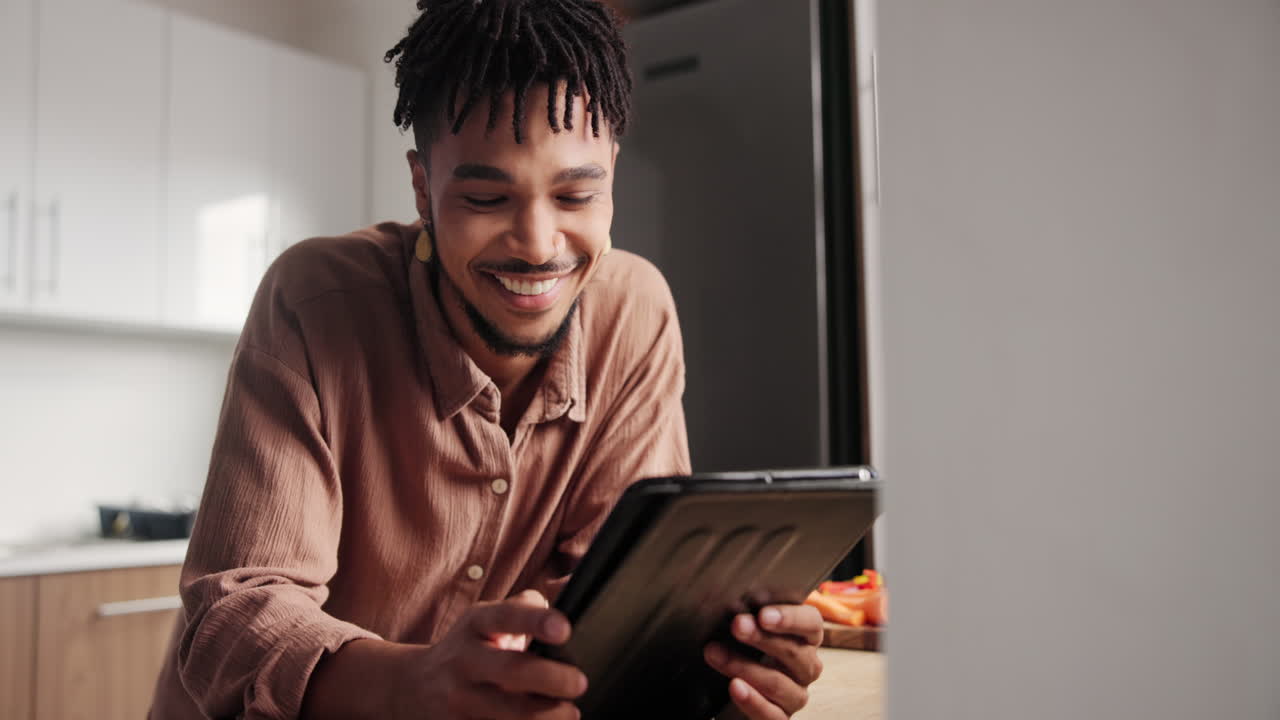 Happy Man Using Tablet in Kitchen