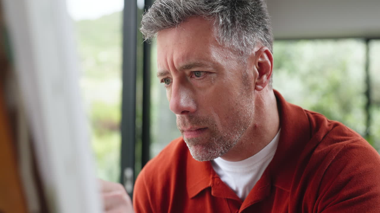 Close-up of Focused Mature Man Painting or Drawing
