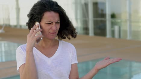 focused brunette businesswoman talking on smartphone outdoor.