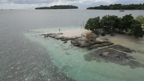 tourist enjoys solitude on tiny tropical island, gilis bedis in bali