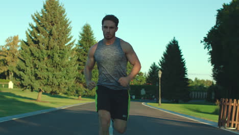 athlete man running in city park while cardio training outdoor. sport lifestyle