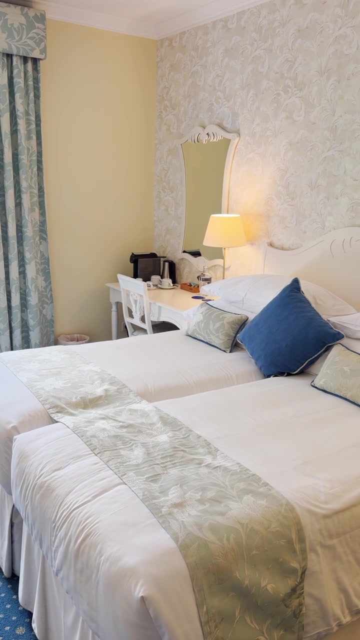 POV on luxury hotel suite bedroom with large king size bed and fancy stylish design and decor. Travel business trip or honeymoon vacation and holiday. Vertical video UGC style by social media vlogger