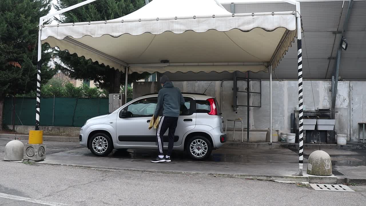 Man Washing His Fiat Panda at an Outdoor Self-Service Car Wash