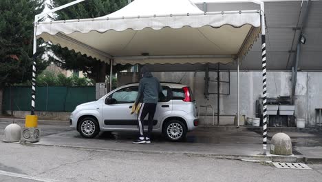 man washing his fiat panda at an outdoor self-service car wash