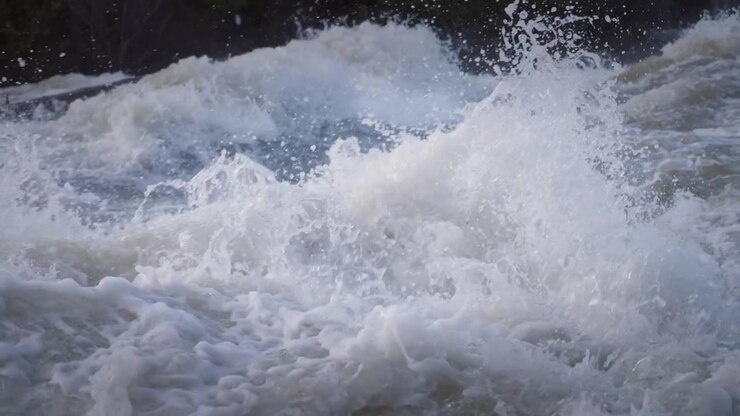 Torrential river water crashes over rocks during the spring runoff. This close view captures the intense spray, dynamic liquid texture, and heavy foam at Sauble Falls on the Bruce Peninsula.