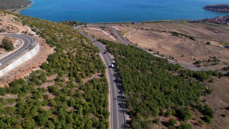 camino panorámico que serpentea en la montaña rocosa con fondo de lago azul, hermoso paisaje en albania