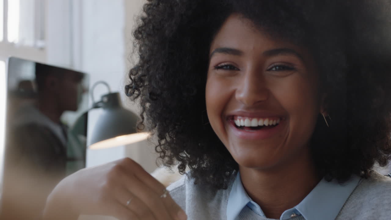 donna d'affari di razza mista con una bella acconciatura afro che chiacchiera con un amico che si gode la conversazione in ufficio