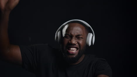 Handsome-male-person-dancing-indoors.-Emotional-afro-guy-singing-in-studio