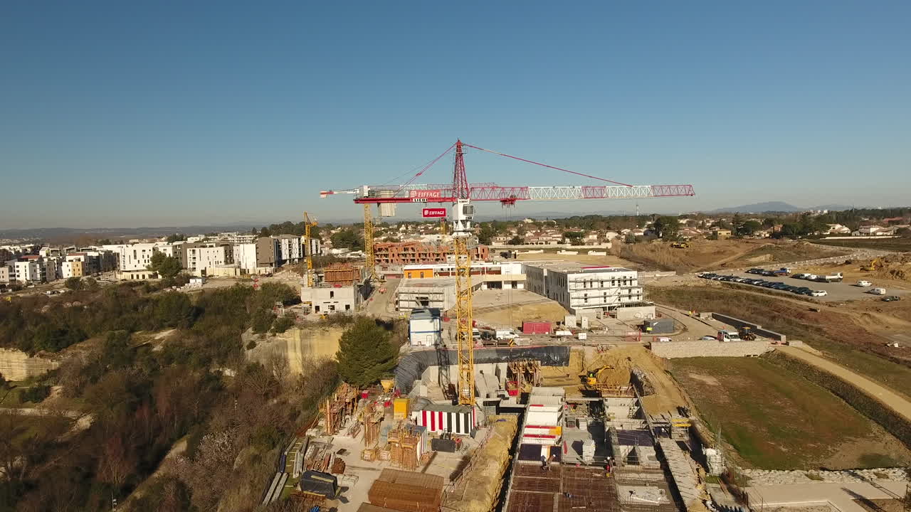 disparo aéreo de un dron volando alrededor de un sitio de construcción con grúas en francia