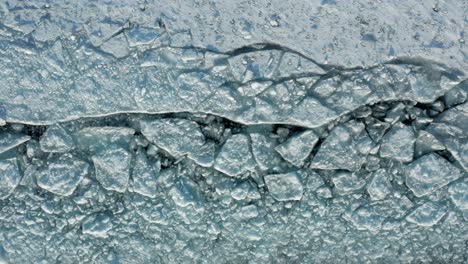 aéreo de arriba hacia abajo, capa de hielo polar rota, luz tenue que crea sombras