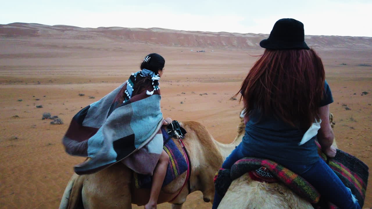 Wind blows through the desert as two riders journey on camels across Oman’s vast dunes. A cinematic moment evoking freedom, stillness, and the allure of Middle Eastern travel.