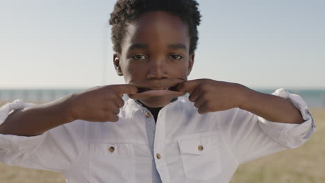 close-up-portrait-of-cute-african-american-boy-making-faces-at-camera-happy-playful-enjoying-sunny-day-at-seaside-park