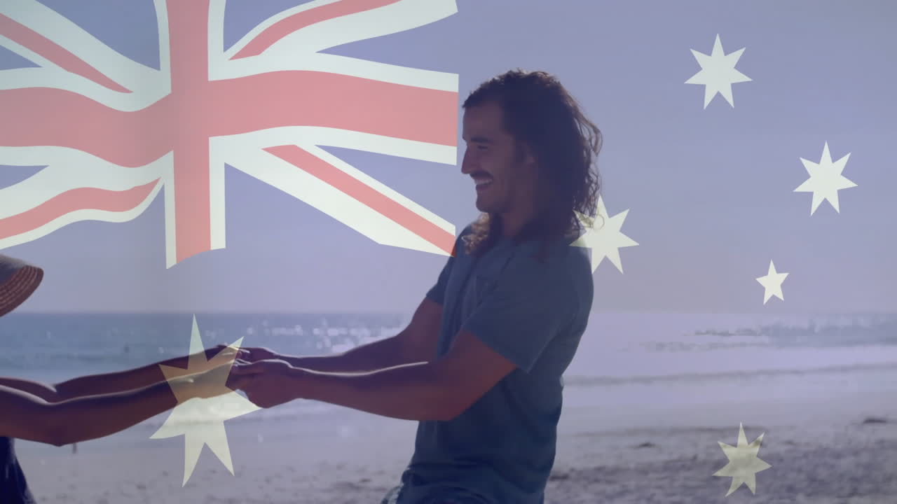 On beach, man and woman holding Australian flag, smiling and having fun