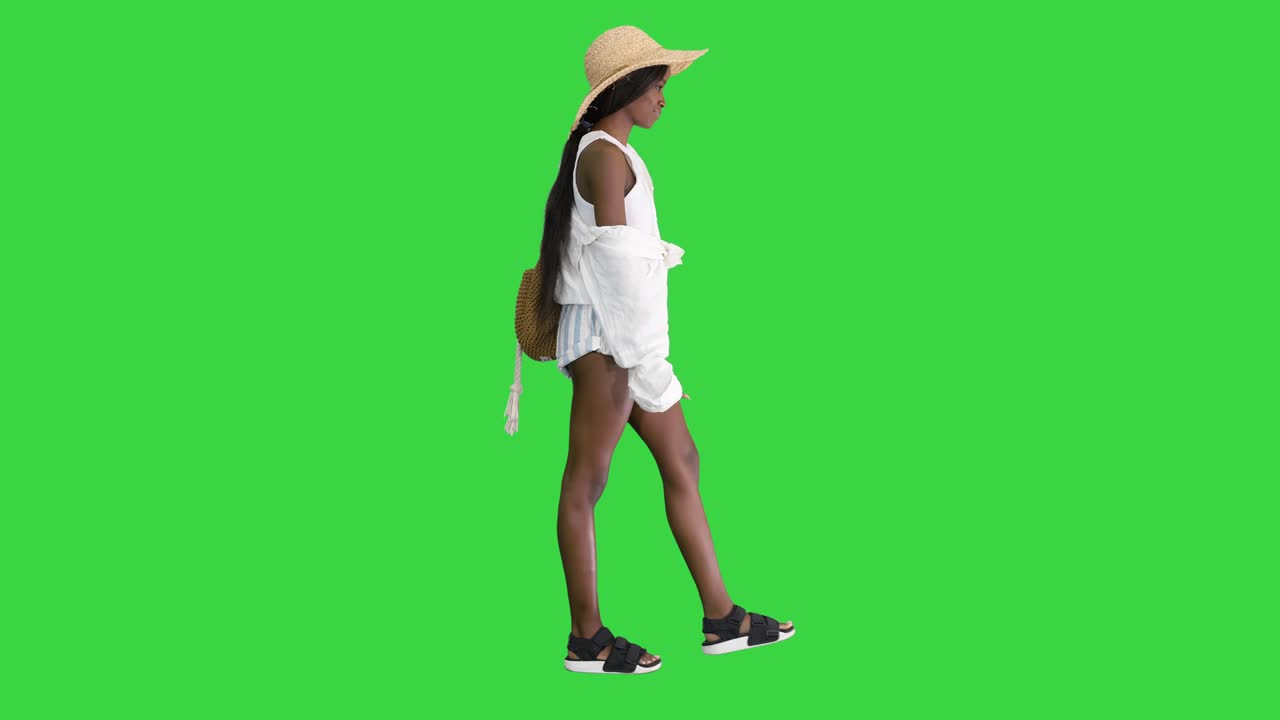 녹색 스크린, 크로마 키에 포즈를 취하는  모자를 입은 미소 짓는 젊은 아프리카계 미국인 여성