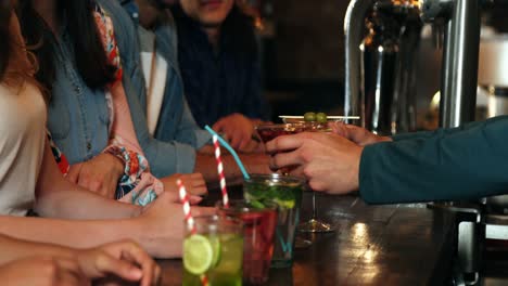 bartender serving cocktail at counter