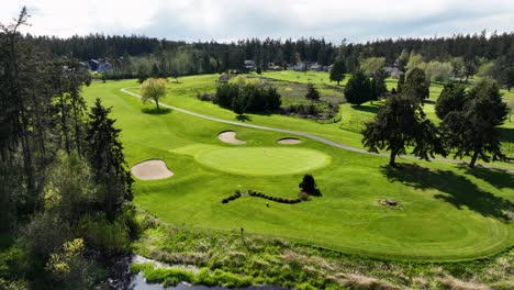 aerial of putting green surrounded by sand traps and a water feature