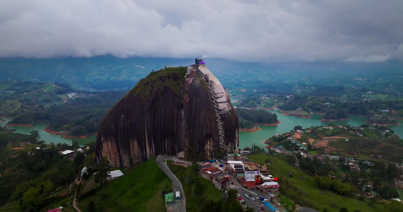 Órbita cinematográfica 4K de dron del monolito La Piedra del Peñol sobre el embalse de Guatapé, área de Medellín, Colombia, hito turístico icónico