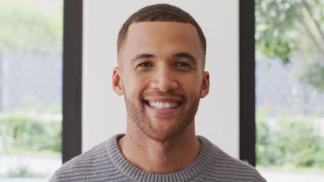 retrato de video de un hombre biracial sonriendo a la cámara en el interior