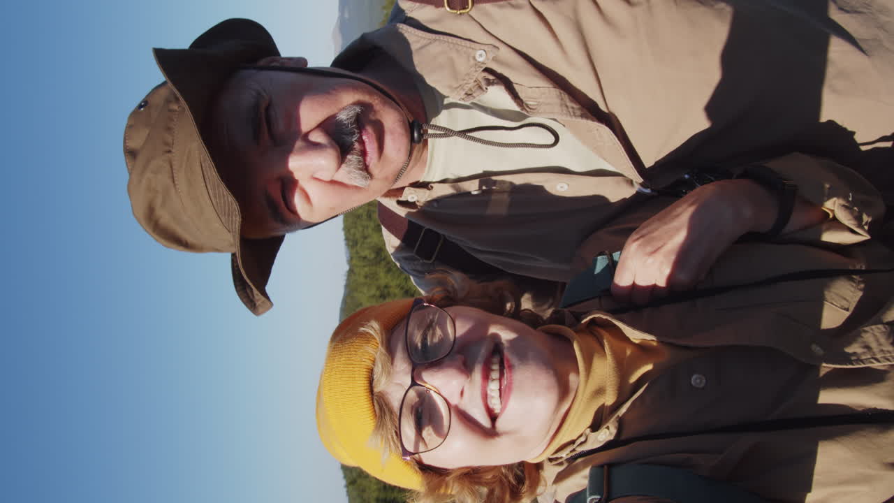 Seniorpar vandrer og tager en selfie i bjergene