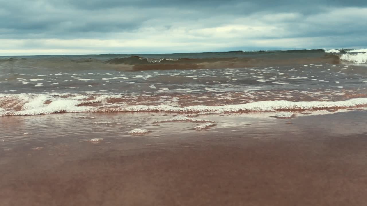Bellissimo paesaggio, un'onda si infrange sulla riva sabbiosa del mare