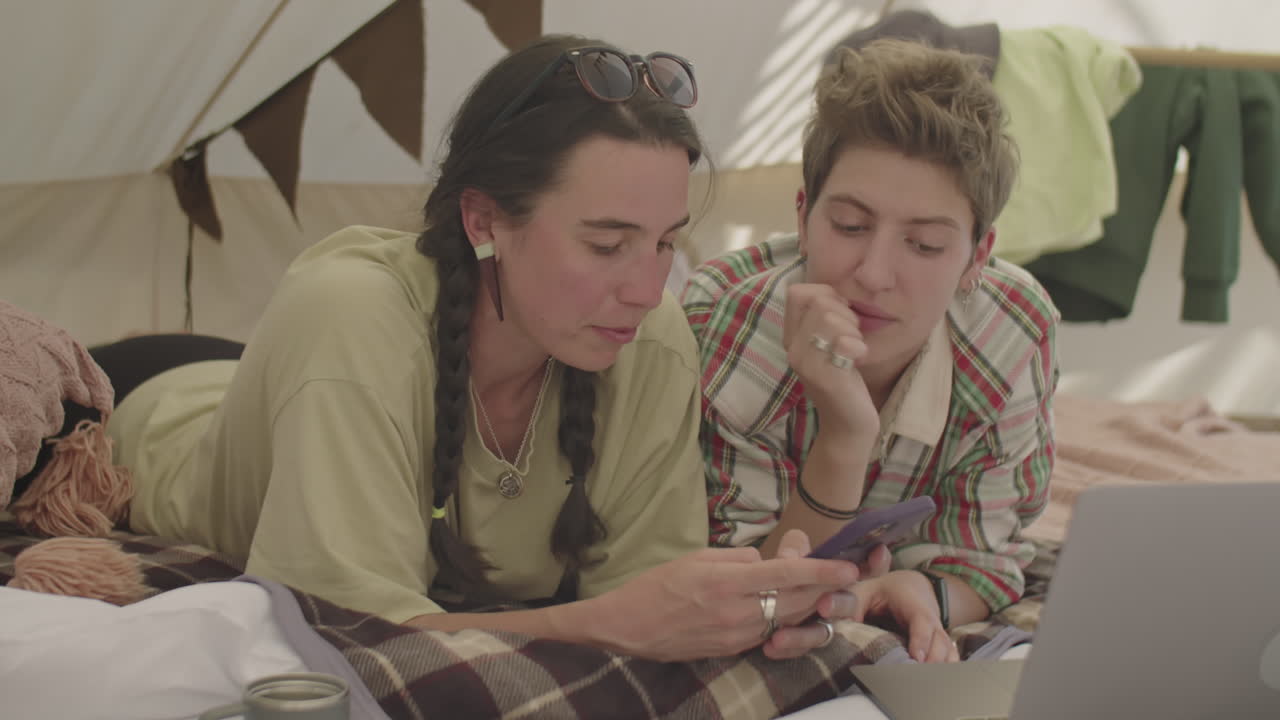Girlfriends Lying in Glamping Tent and Using Smartphone