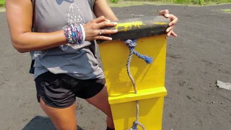 latina woman excited about sledding down volcanic ash slope, nicaragua