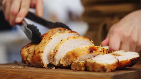 crop chef cutting appetizing roasted chicken in kitchen