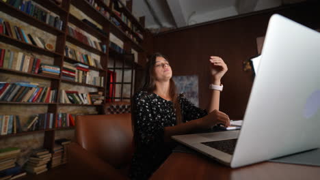 mujer trabajando en una computadora portátil en una biblioteca