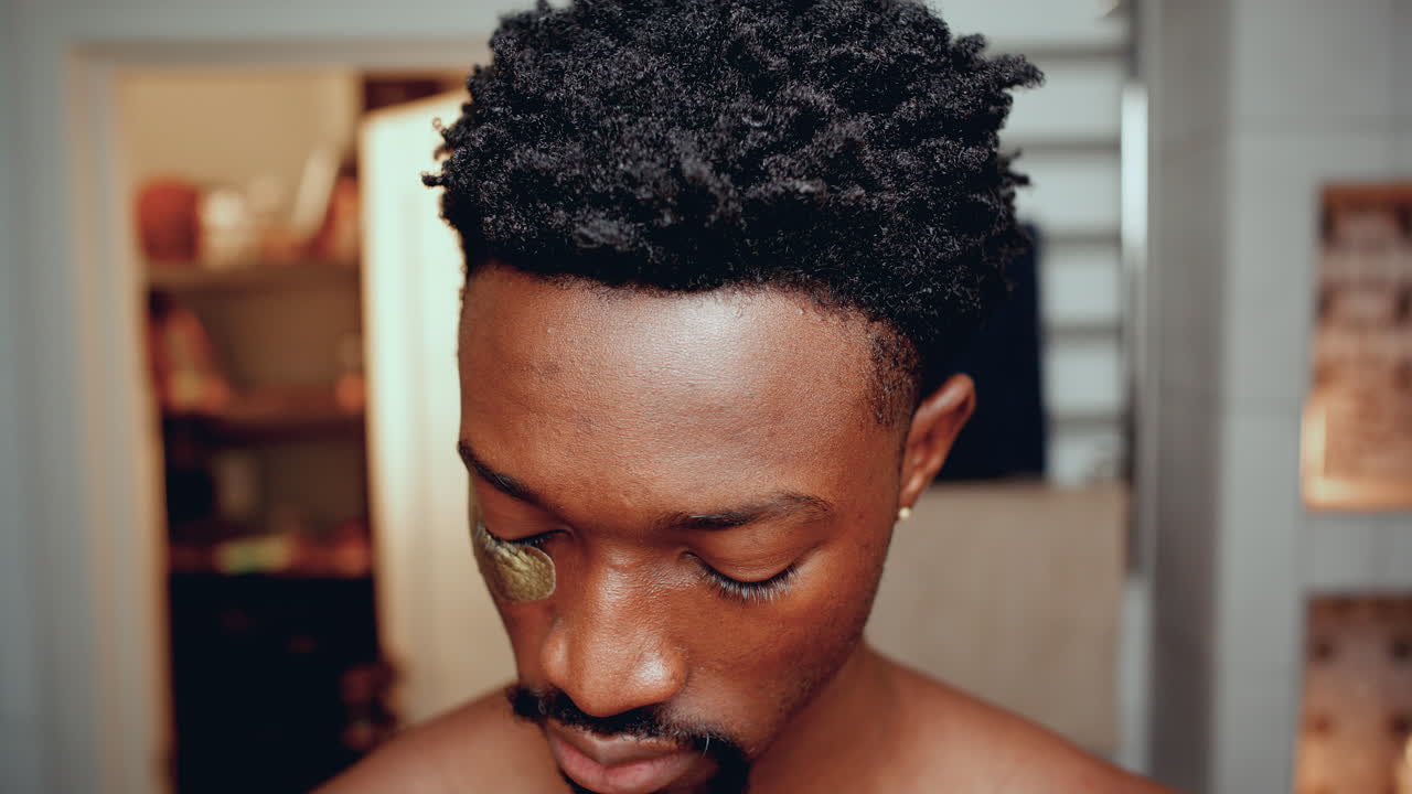 젊은 아프리카계 미국인 남자가 눈 에 패치를 붙이고 카메라를 향해 미소 짓고 있다