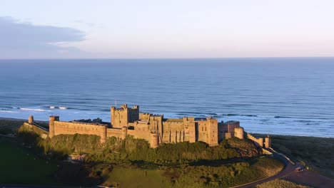 Toma-Aérea-De-Drones-Al-Atardecer-Del-Castillo-De-Bamburgh-En-Northumberland,-Reino-Unido