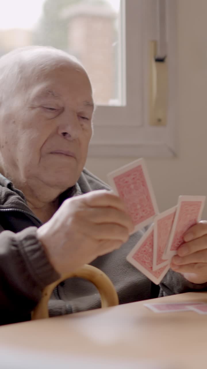 Senior man sorting cards ready to play in a geriatric