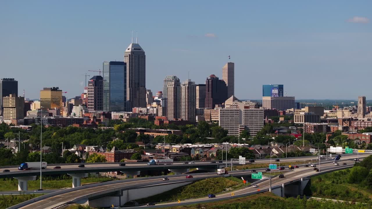 Drone ascends over green park to reveal downtown Indianapolis skyline on summer day