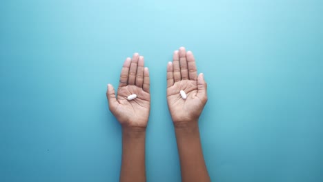 hands holding white pills