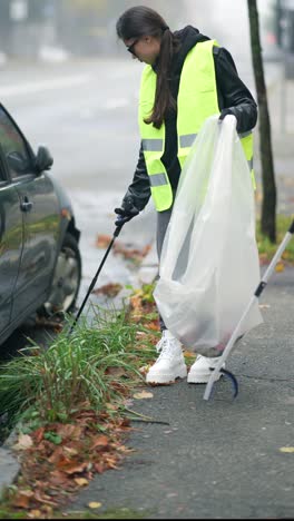 mujer limpiando la basura en la calle