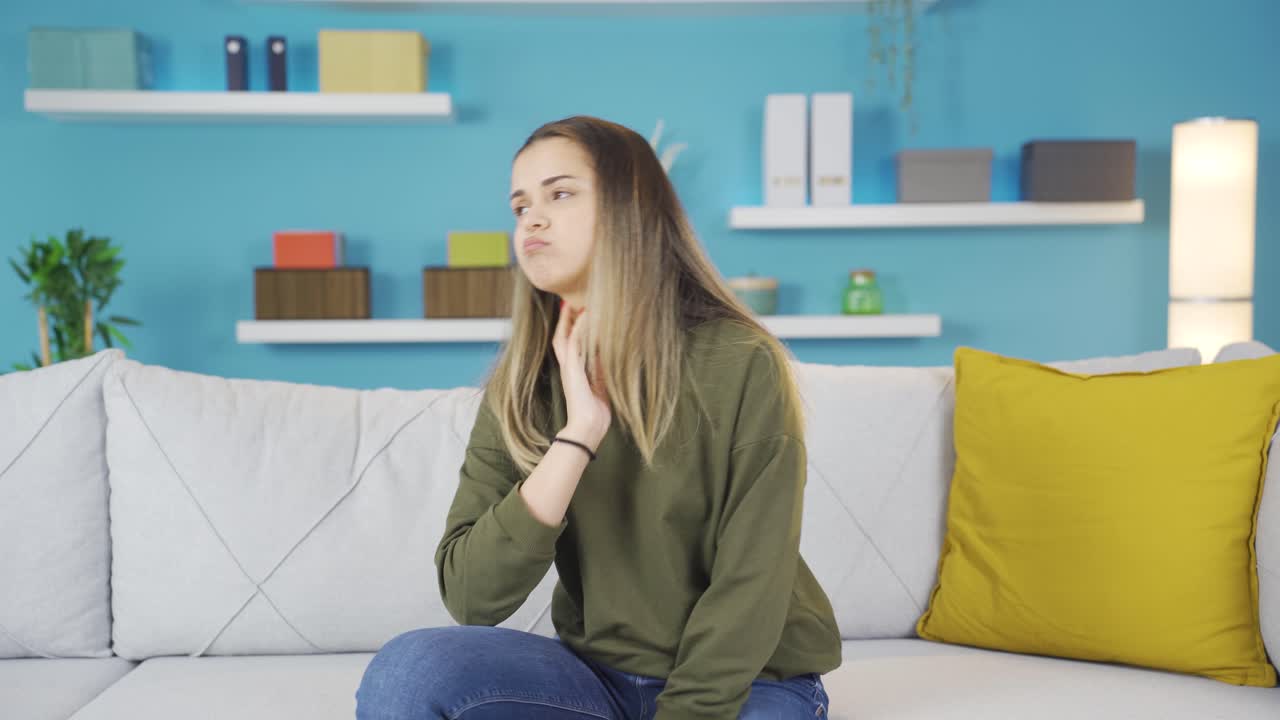 una adolescente deprimida mira a la cámara con gran tristeza.