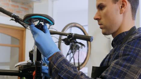 Man-repairing-bicycle-in-workshop-4k